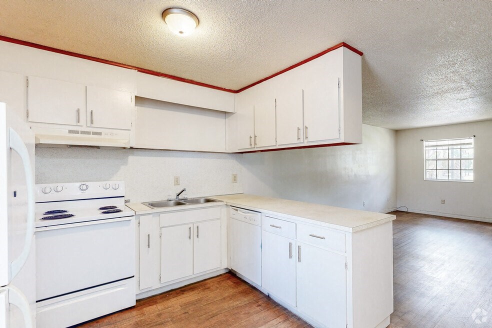 an empty kitchen with white appliances and white cabinets