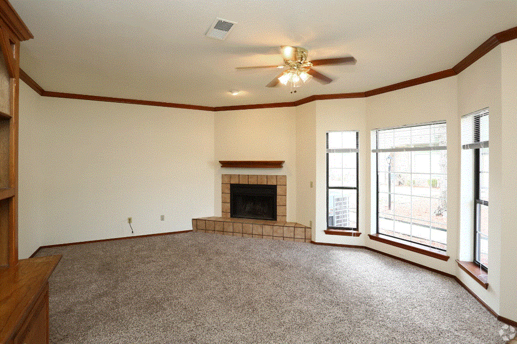 a living room with a fireplace and a ceiling fan