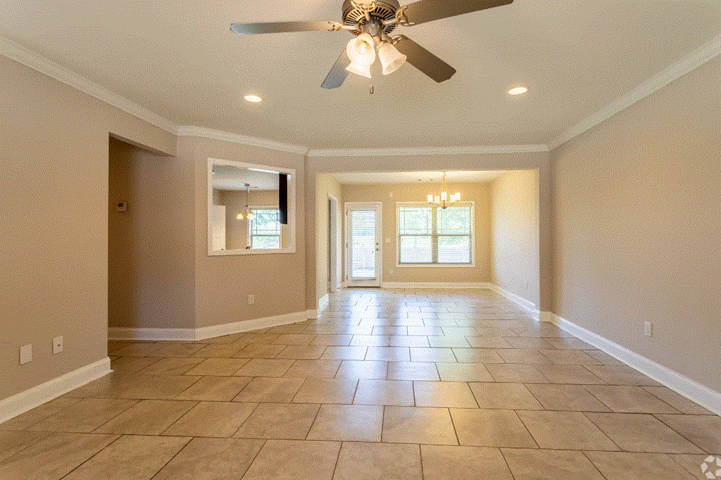 an empty living room with a ceiling fan