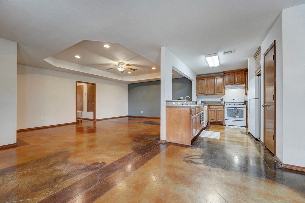 a kitchen and living room with white walls and wood floors
