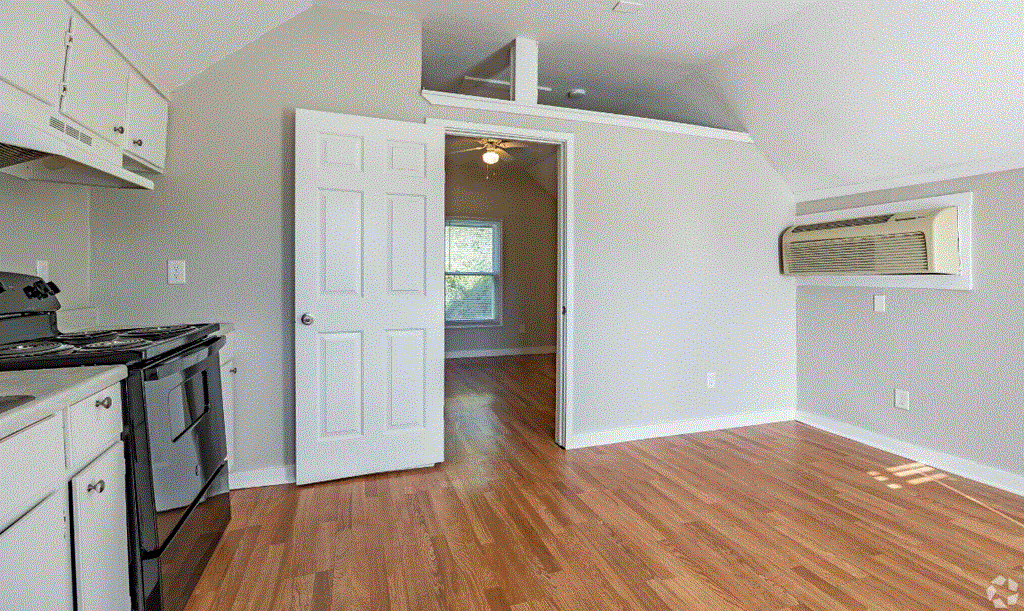 an empty kitchen and living room with an open door
