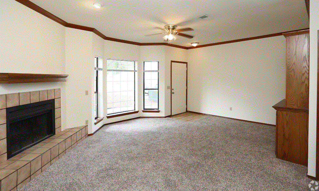a living room with a fireplace and a ceiling fan