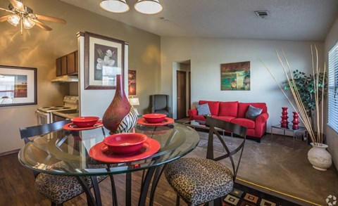 a dining room and living room with a glass table and chairs