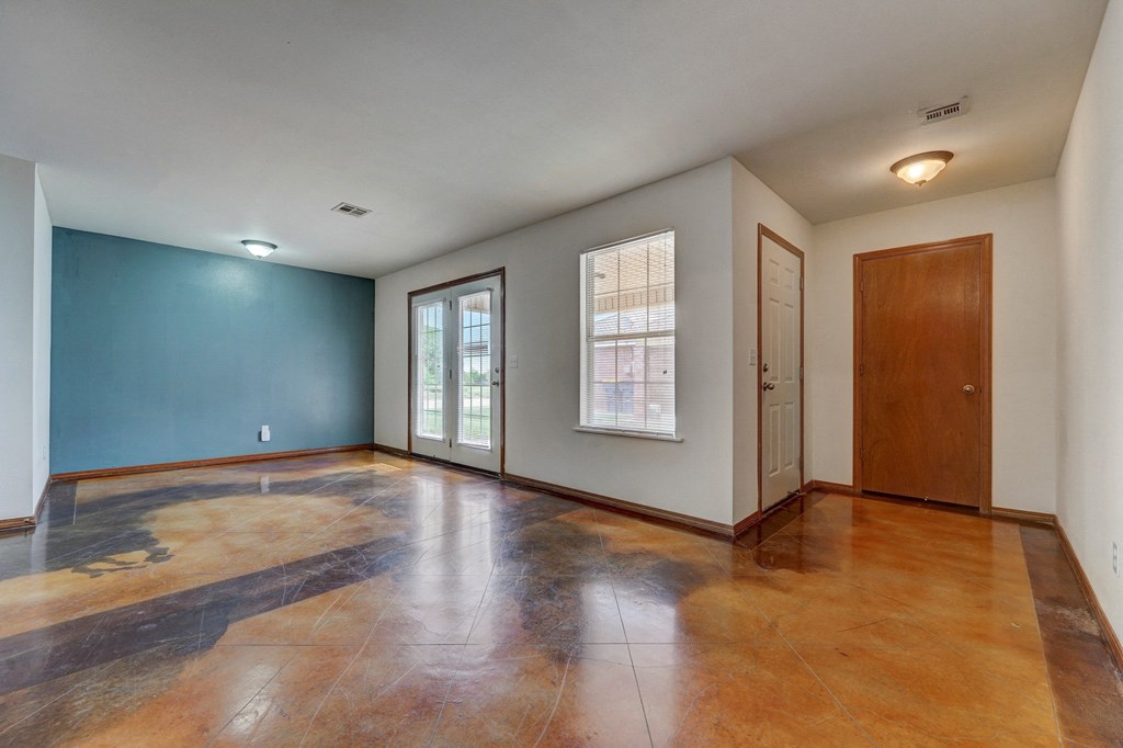 an empty living room with a blue accent wall