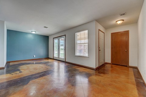 an empty living room with a blue accent wall