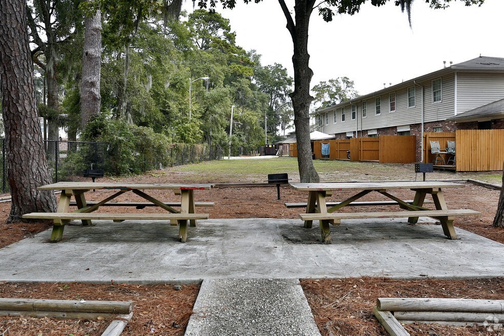 two picnic tables in a park in front of a building