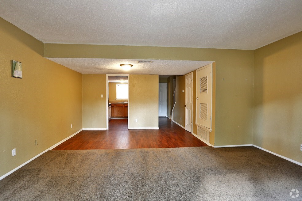 an empty living room with hard wood floors and yellow walls