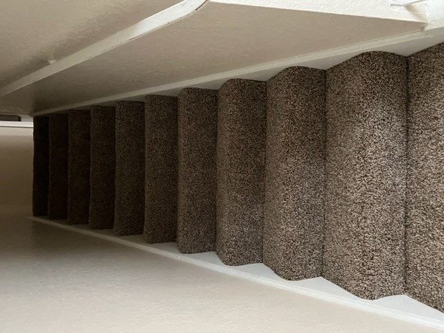 a long white shelf with a bunch of brown curtains on it