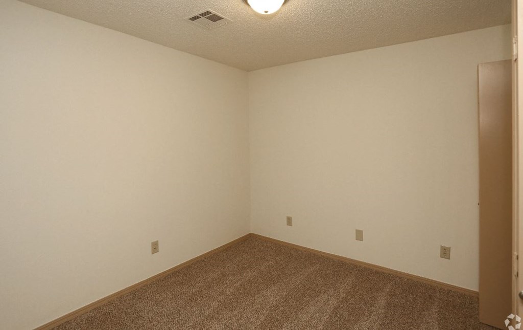 an empty room with a carpeted floor and a door