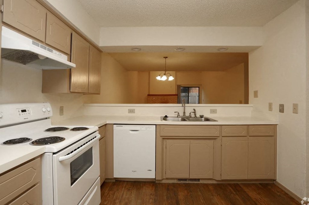 an empty kitchen with white appliances and white cabinets