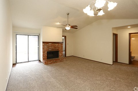 a living room with a fireplace and a ceiling fan
