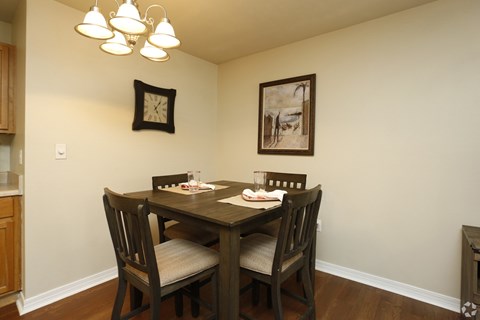 A dining room with a wooden table and chairs.