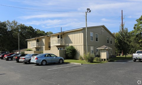 A parking lot with cars and a building in the background.