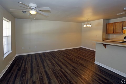 A room with a ceiling fan and wooden flooring.