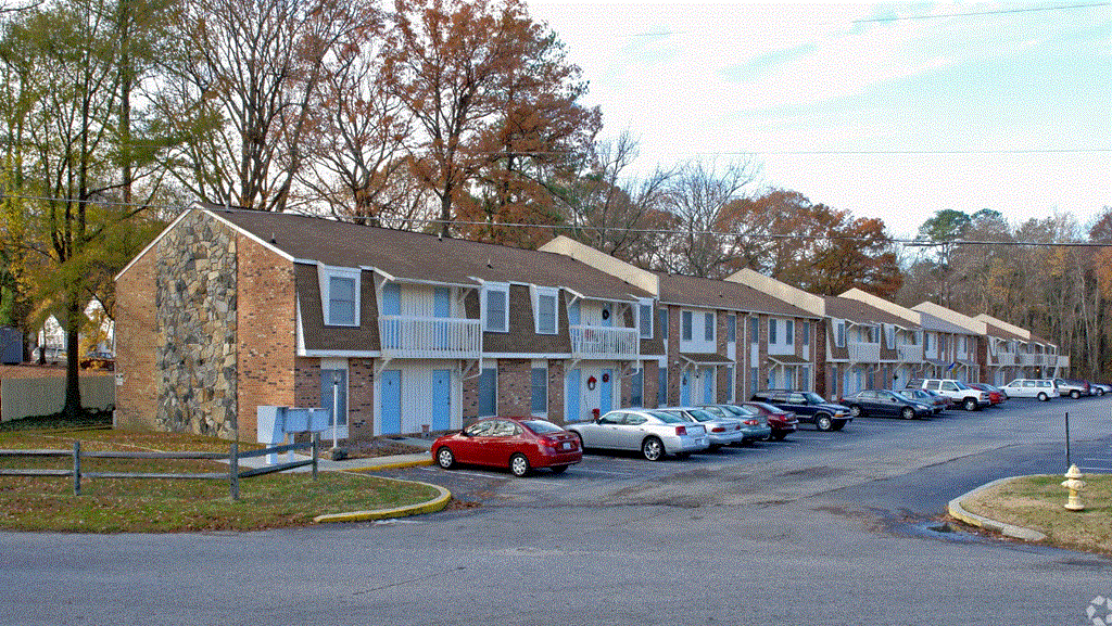a row of houses with cars parked in front of them