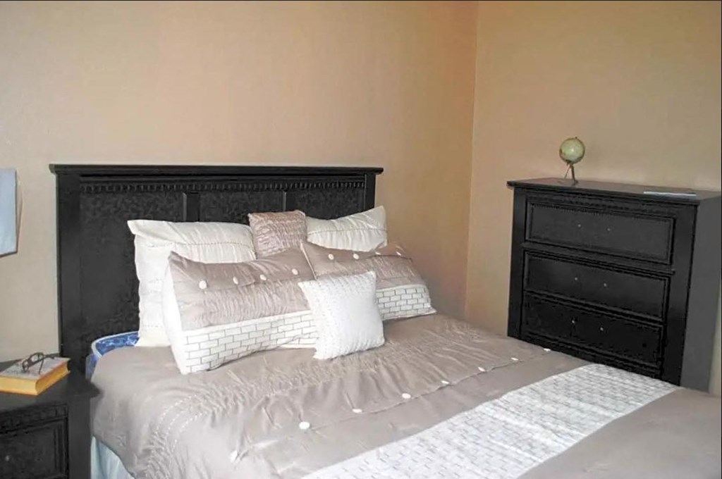 a bedroom with a bed and a dresser