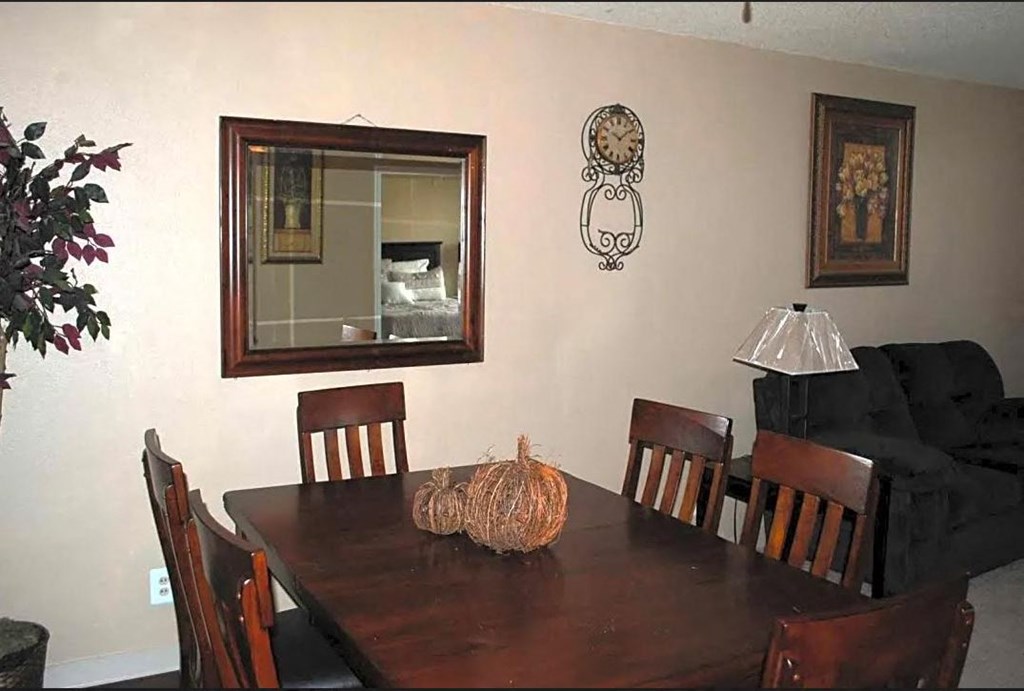 a dining room table with a mirror on the wall