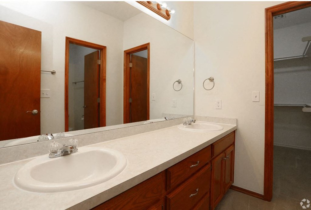 a bathroom with two sinks and two mirrors