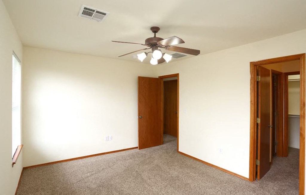 a living room with a ceiling fan and a door