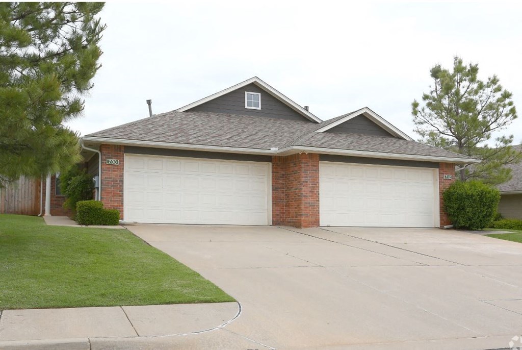 a house with two garage doors in front of a driveway