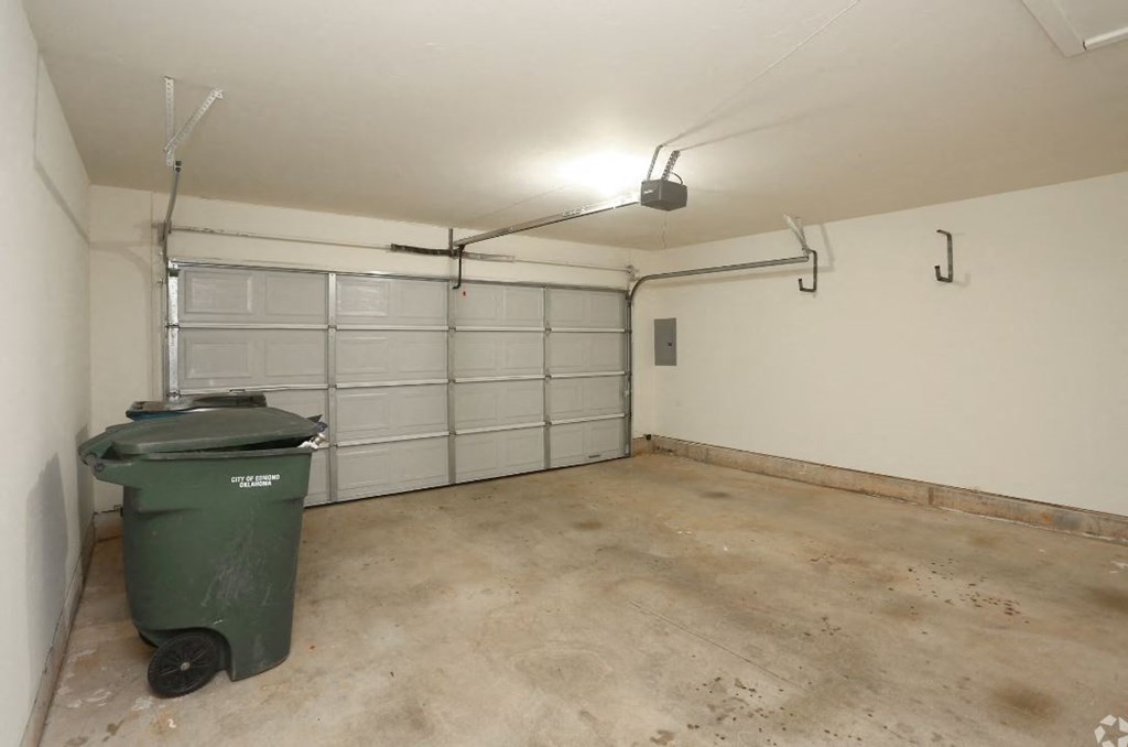the inside of a garage with a garbage can