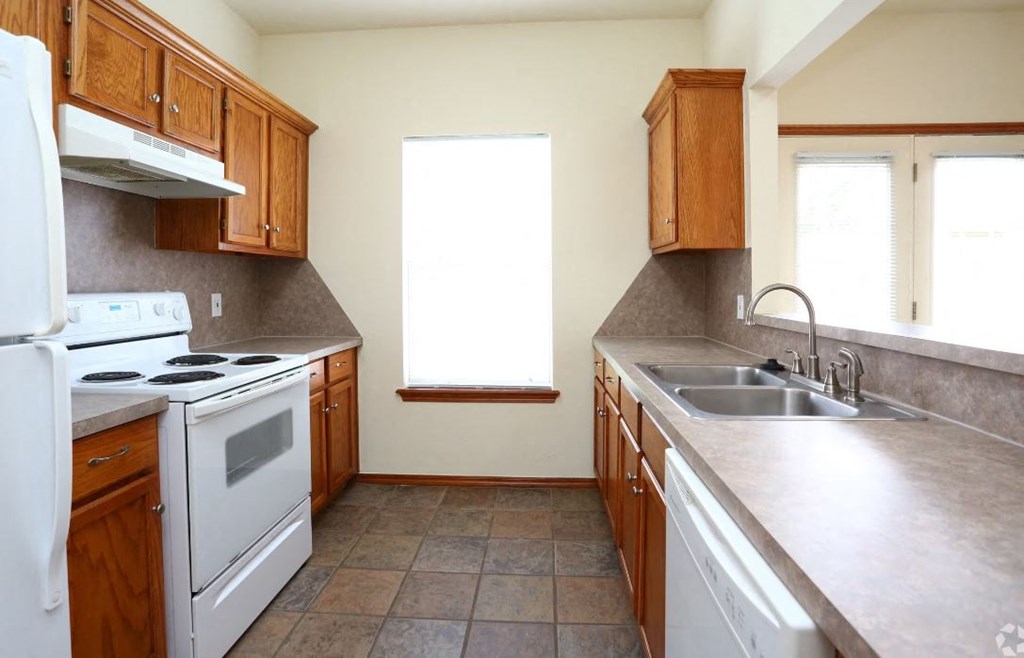 a kitchen with white appliances and wooden cabinets