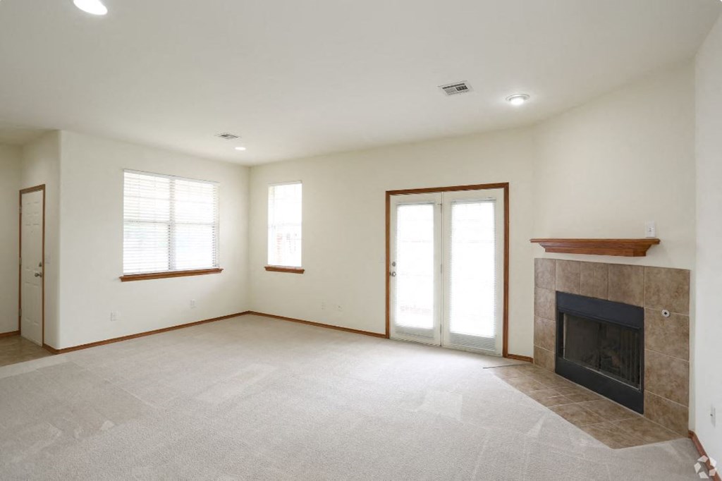 an empty living room with a fireplace and a window