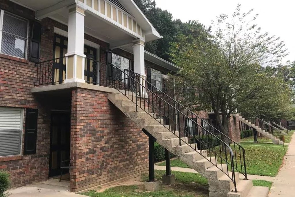 an old brick building with stairs and a porch
