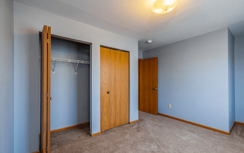 a empty room with a closet and a door to a bathroom