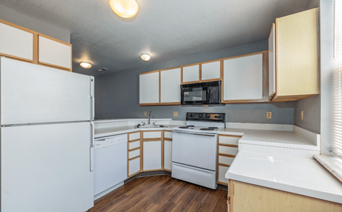 a kitchen with white appliances and wooden cabinets