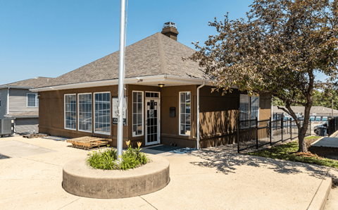 a small brown building with a flagpole in front of it