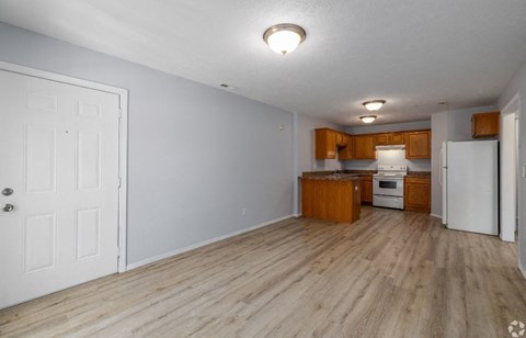 a kitchen and living room with a wooden floor
