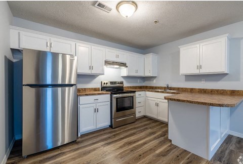 a kitchen with white cabinets and a stainless steel refrigerator
