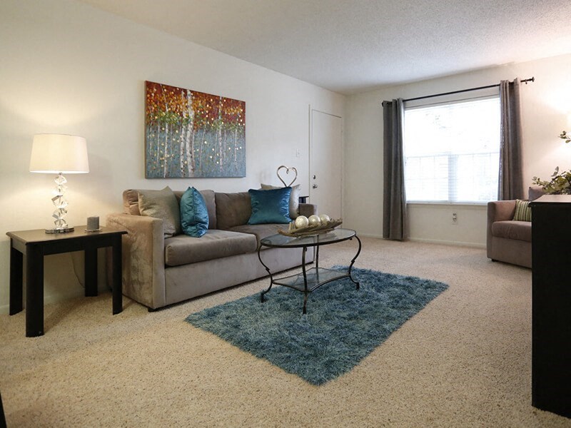a living room with a couch and a table in front of a window