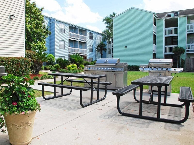 a couple of picnic tables sitting next to a grill