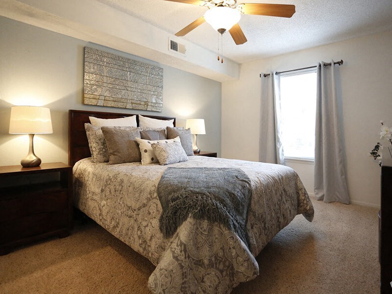a bedroom with a bed and a ceiling fan