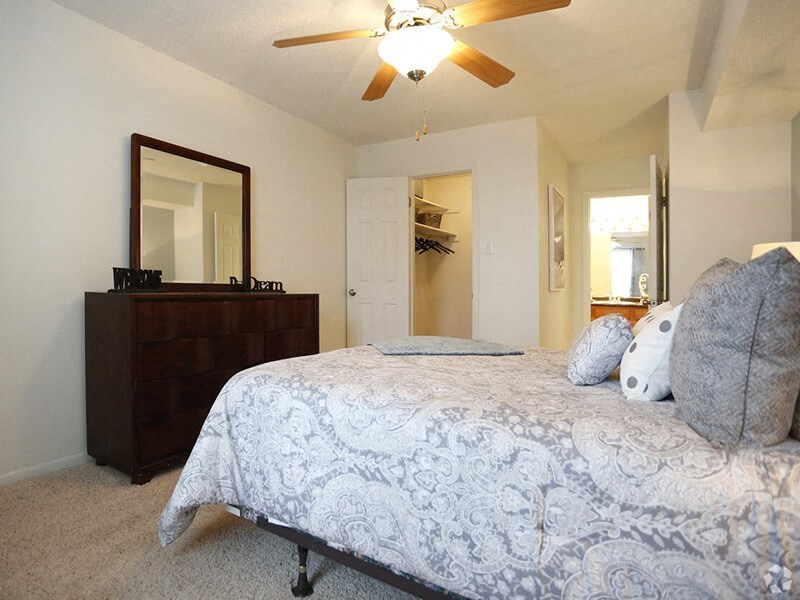 a bedroom with a bed and a ceiling fan