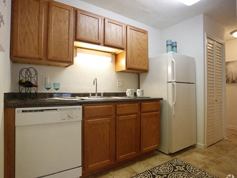 a kitchen with a white refrigerator freezer next to a dishwasher