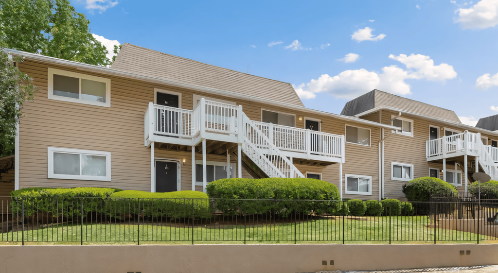 the view of an apartment building with stairs and a fence