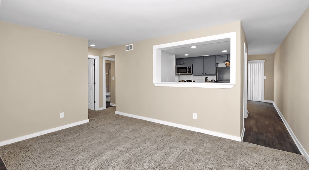 a living room with a large window and a carpeted floor