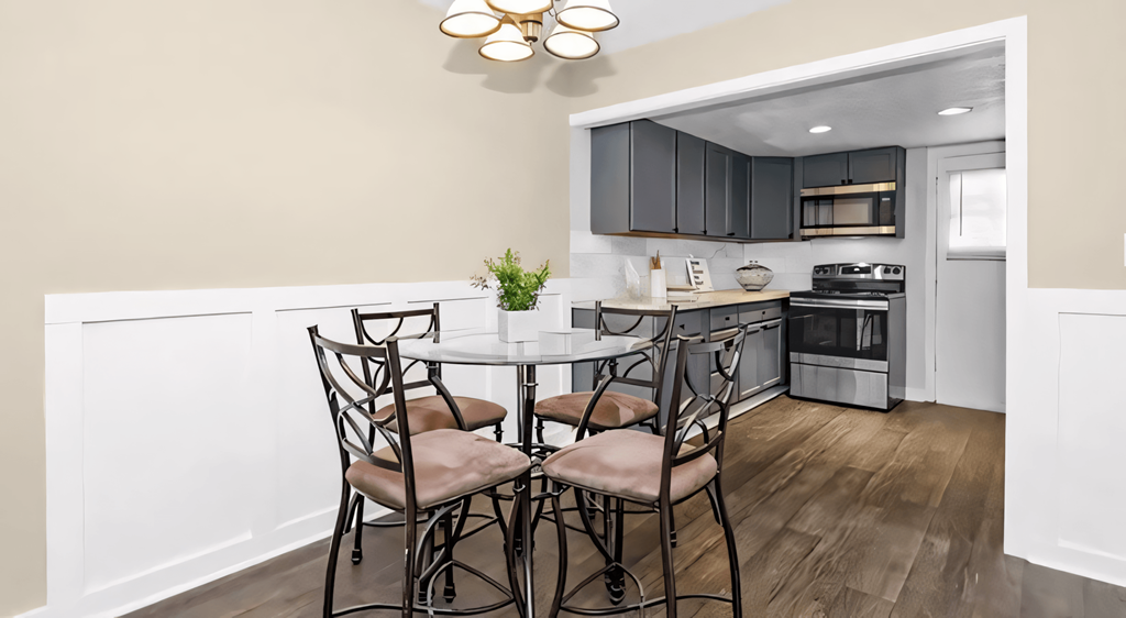 a kitchen with a round table with four chairs