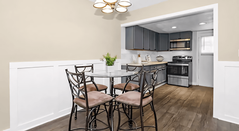 a kitchen with a round table with four chairs