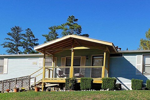 a blue house with a yellow porch and a blue sky