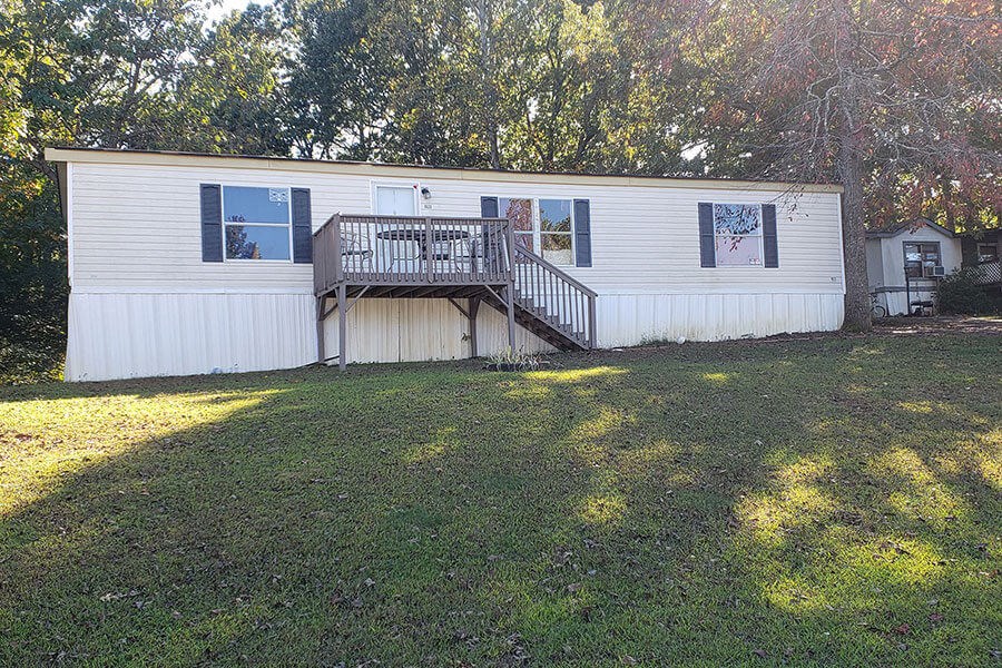 a mobile home with a large yard in front of it