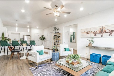 A living room with a zebra print rug and white chairs.