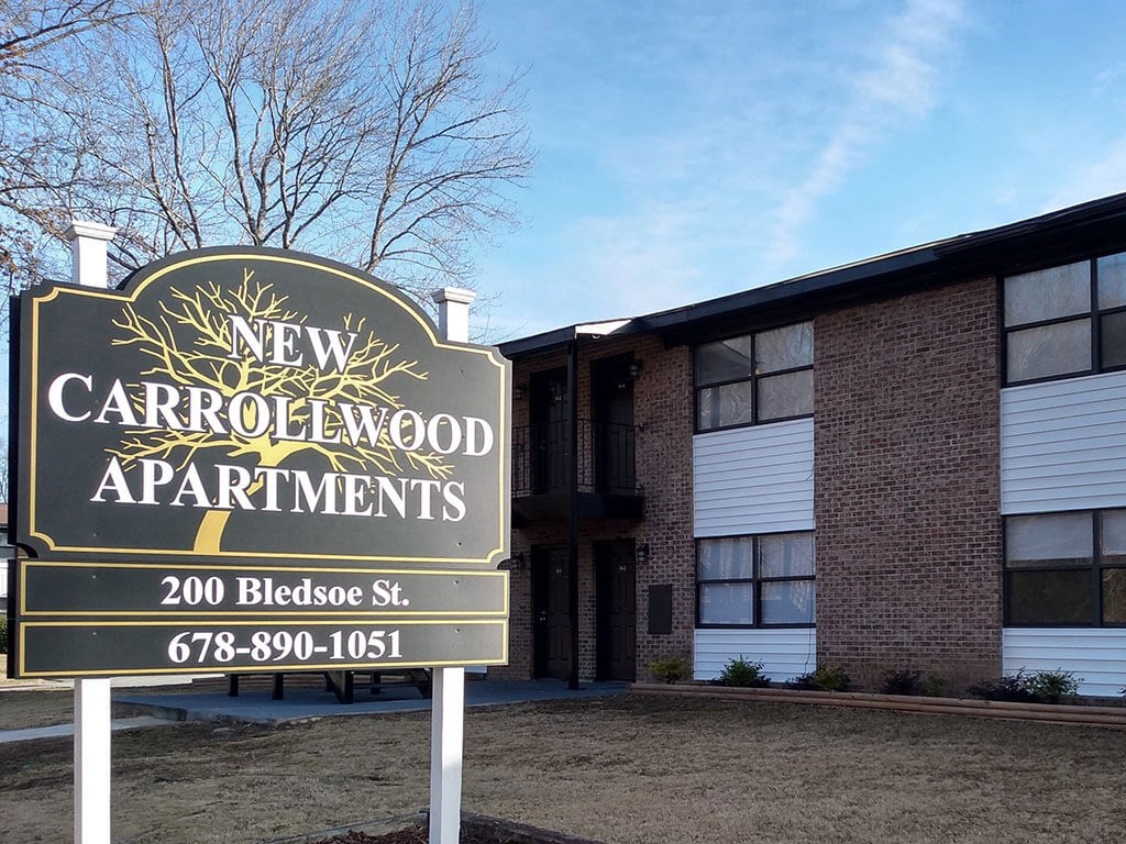 a sign in front of a building that says new carrollwood apartments