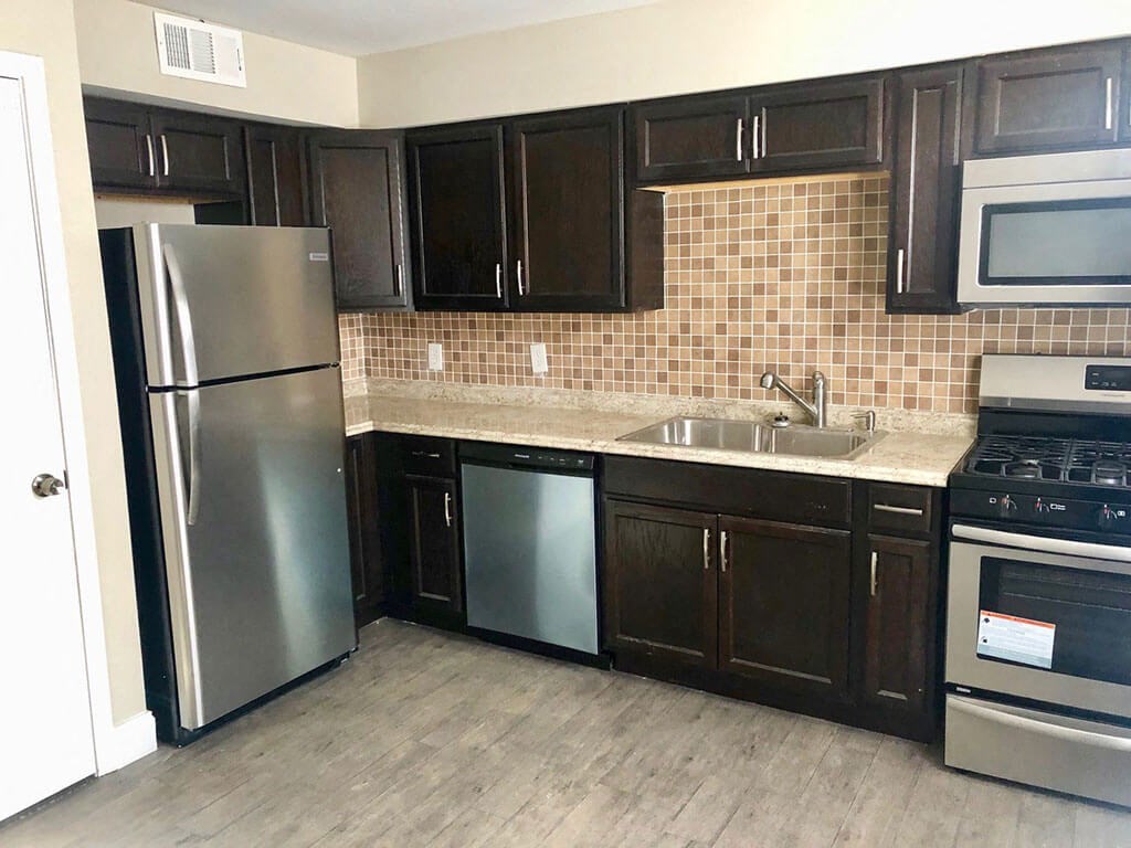 a kitchen with black cabinets and stainless steel appliances