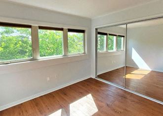 a bedroom with a large window and a mirror