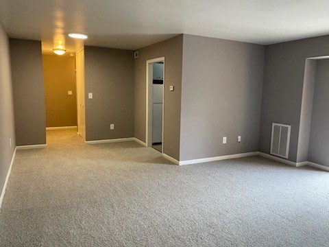 an empty room with gray walls and a white carpet