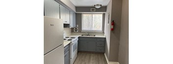 a kitchen with a stove a sink and a window